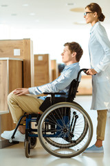 doctor rolling man in wheelchair