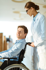 Obraz premium doctor rolling man in wheelchair