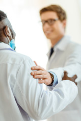 Obraz premium doctor patting colleague on shoulder