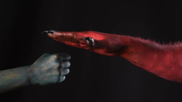 Demon and troll playing rock paper scissors game.