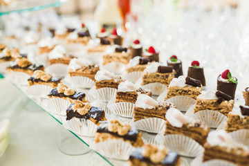 Delicious sweets on wedding candy buffet with desserts, cupcakes