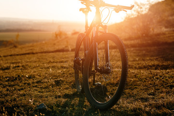 Fototapeta na wymiar Mountain bike stands alone outdoor against autumn sunset landscape