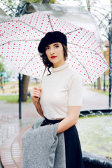 Young Parisian woman walking under the rain