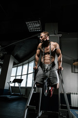 Strong man with tatoo working in gym 