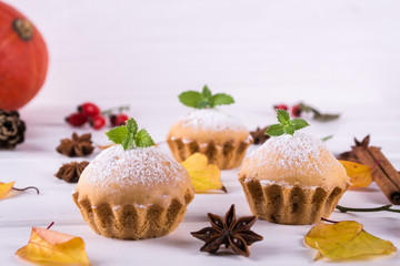 Autumn pastries. Homemade cupcakes with powdered sugar with cinnamon sticks, anise stars and autumn leaves