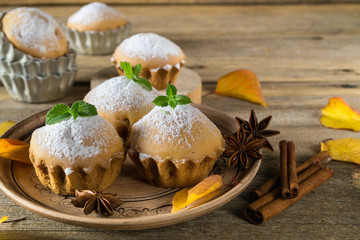 Autumn pastries. Homemade cupcakes with powdered sugar with cinnamon sticks, anise stars and autumn leaves