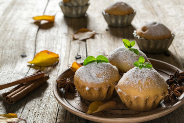 Autumn pastries. Homemade cupcakes with powdered sugar with cinnamon sticks, anise stars and autumn leaves