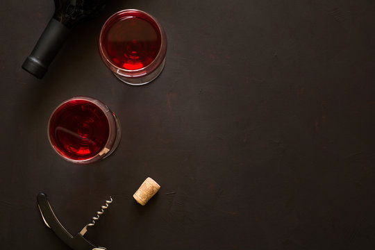 Fototapeta Two wineglasses with red wine and lying bottle on brown wooden desk
