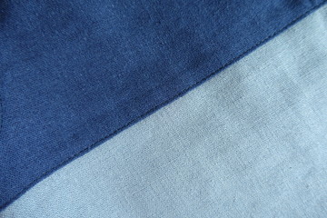 Top view of blue linen fabric with diagonal seam