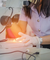   Student girl looking through microscope in science laboratory study research experiments about...