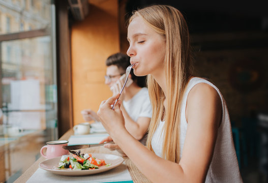 Portrait of attractive caucasian smiling woman eating salad