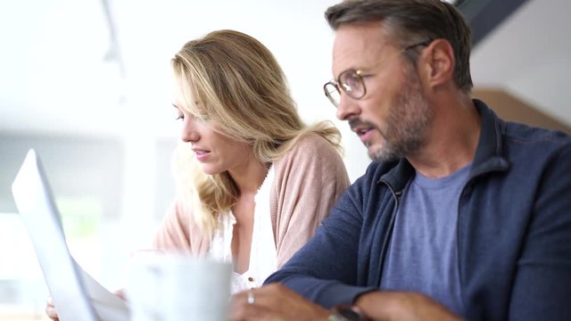 Mature couple at home working on laptop computer