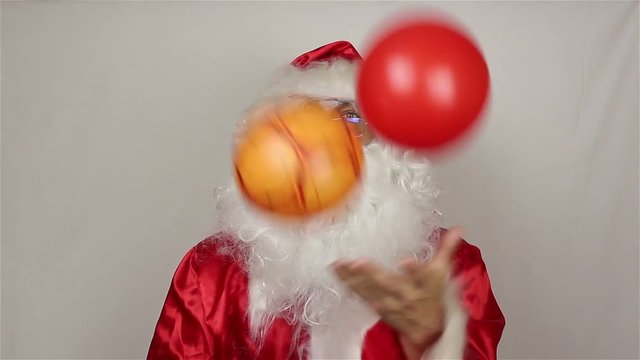 Santa Claus juggles with colorful balls