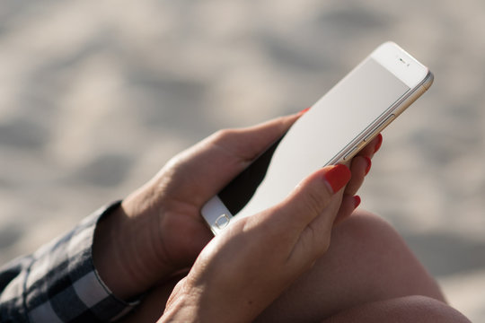 Beautiful Girl Holding A Smartphone In The Hands Of A Green Screen Green Screen On The Beach Near The Sea Shore Sand In The Background