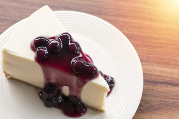Blueberry cream cheesecake in white plate on wood table