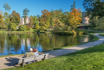 Happy elderly couple resting in a city public park