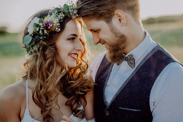 Beautiful bride and groom at sunset in green nature.