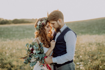Beautiful bride and groom at sunset in green nature.