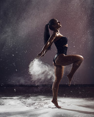 Graceful woman dancing in cloud of dust © VlaDee