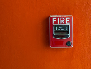 Fire alarm on red wall