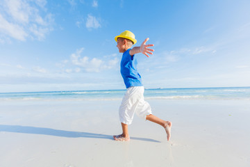 Fototapeta na wymiar Boy having fun on tropical ocean beach. Kid during family sea vacation.