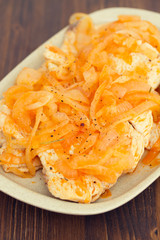 turkey with onion on dish on wooden background