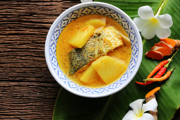 Yellow curry snapper fish with pineapple , thai food and vegetable in white dish / selective focus and top view image