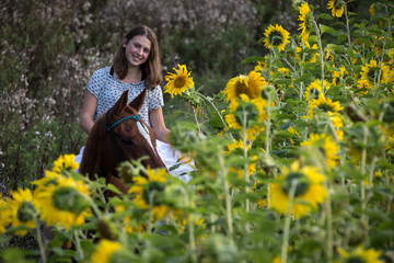 Naklejka na ściany i meble Mädchen mit Pferd in Sonnenblumen