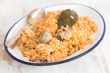 rice with seafood and fish on dish on wooden background