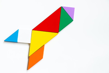Colorful wood tangram puzzle in rocket or missile shape on white background