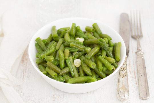 boiled green beans with garlic in white bowl