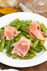 boiled beans with smoked meat on white dish