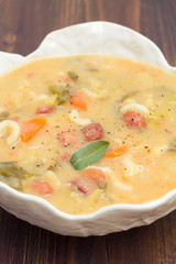 vegetable soup with beans, spinach and pasta in white bowl