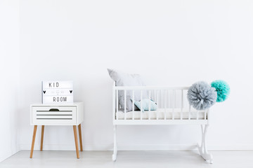 White cradle with pastel pompons