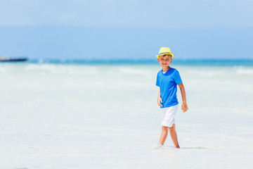 Boy having fun on tropical ocean beach. Kid during family sea vacation.