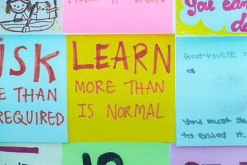 "Learn more than is nomal" Message on post-it color note for background.