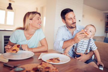 Obraz na płótnie Canvas Happy lovely family eating pizza