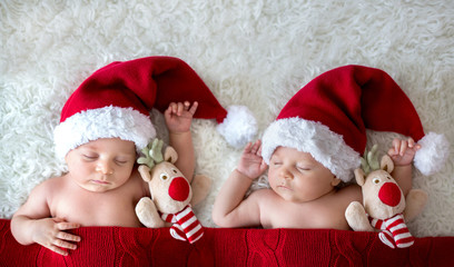 Little sleeping newborn baby boy, wearing Santa hat