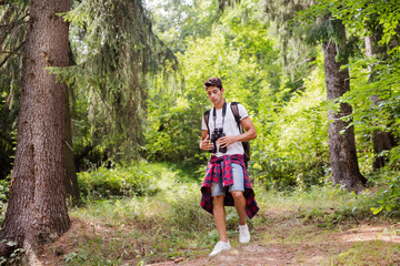 Teenage boy hiking in forest. Summer vacation.