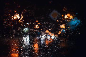 Fototapeta na wymiar Magnificent city landscape in the side through the wet windshield of the car in the rain. Beautiful background