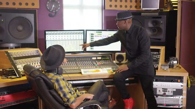  Music producer & sound engineer working together in recording studio
