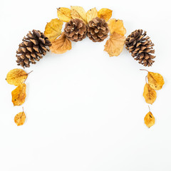 Frame made of autumn leaves and pine cones on white background. Flat lay, top view
