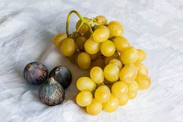 bunch of white grapes with three black figs