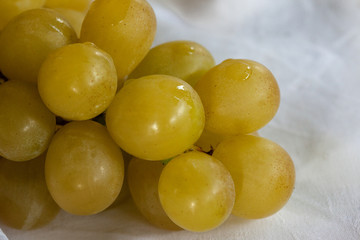 bunch of white grapes on a white tablecloth