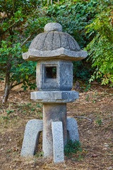 Fototapeta na wymiar Stone Japanese garden lantern in the garden