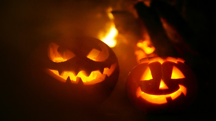 Creepy halloween pumpkins near a fireplace. Fire on the background.