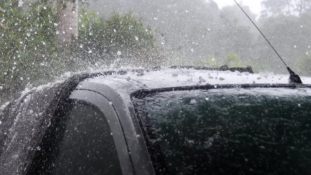 Hail stones pelting roof of car during violent storm