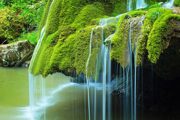detail of beautiful waterfall full of green moss