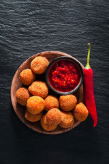 Fried Arancini rice balls . Typical Sicilian street food with spicy sauce
