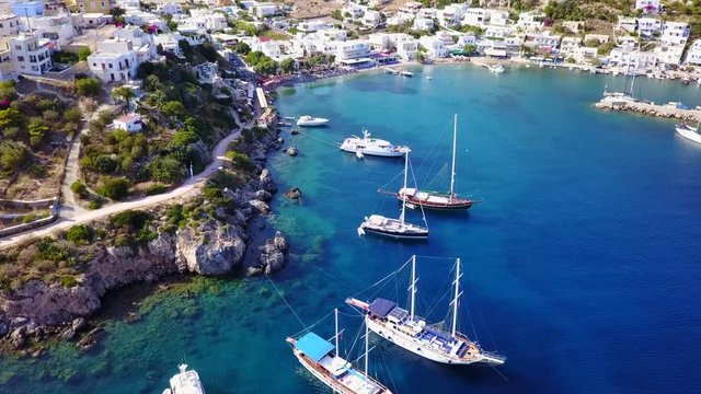 August 2017: Aerial drone video from picturesque village of Panteli with view to iconic fortified castle and windmills uphill, Leros island, Dodecanese, Greece